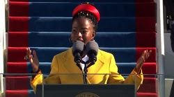 Amanda Gorman in a yellow coat performing her inauguration poem